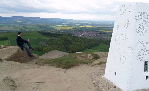 The summit of Roseberry Topping, the graffiti ridden old 'trig' point, and a view of Great Ayton Village below and across to the Cleveland Hills.