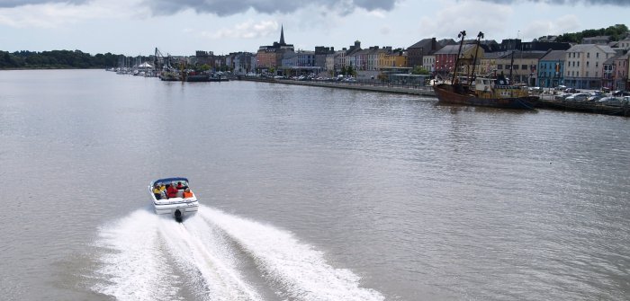 Looking east down the River Suir from the Town to Ferrybank road bridge as a motor boat speeds by - River Suir waterfront-quays scenes, Waterford Town-City, County Waterford, Ireland
