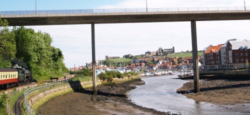 Passing under the Whitby-Scarborough Road bridge with St Mary's Church and Whitby Abbey on the distant cliff horizon.