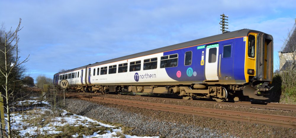 A Northern Rail Class 156 DMU passing the site of Gilsland station with a Carlisle to Newcastle service