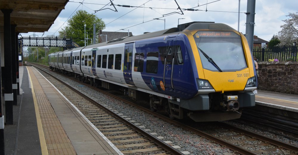 An electric multiple unit At Rainhill station with a Northern Rail Service from Manchester Airport to Liverpool Limes Street station.