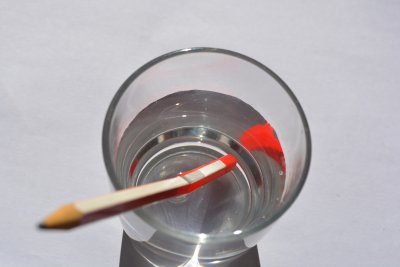 object in water seems bent distorted due to refraction of light rays through water air boundary gcse physics igcse